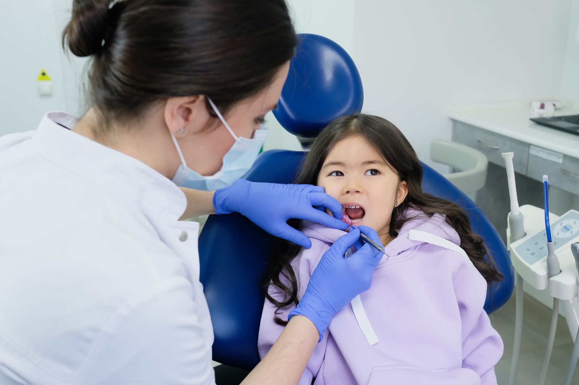 Dentist performing a routine dental checkup on a young child in a clinic