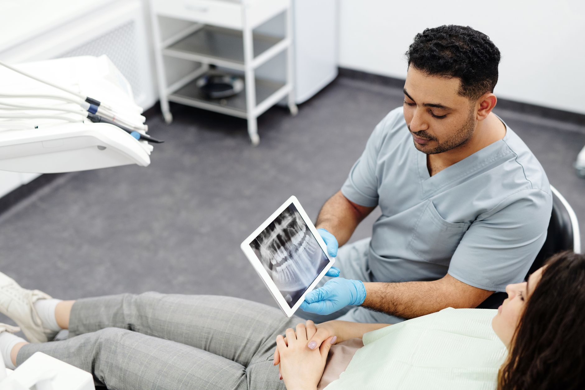 Dentist showing a dental x-ray on a tablet to a patient