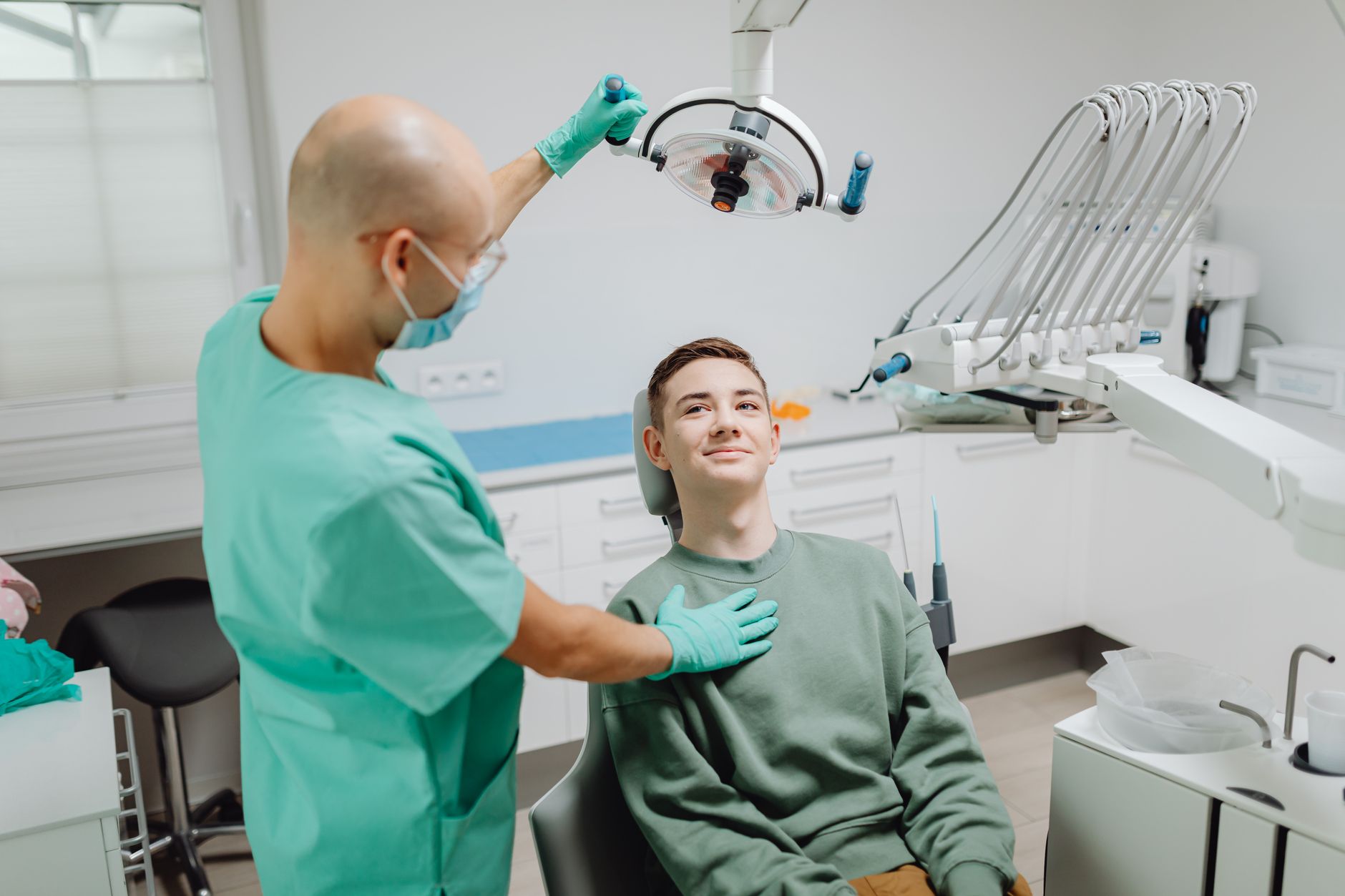 Dentist examining a patient under dental light in a modern clinic