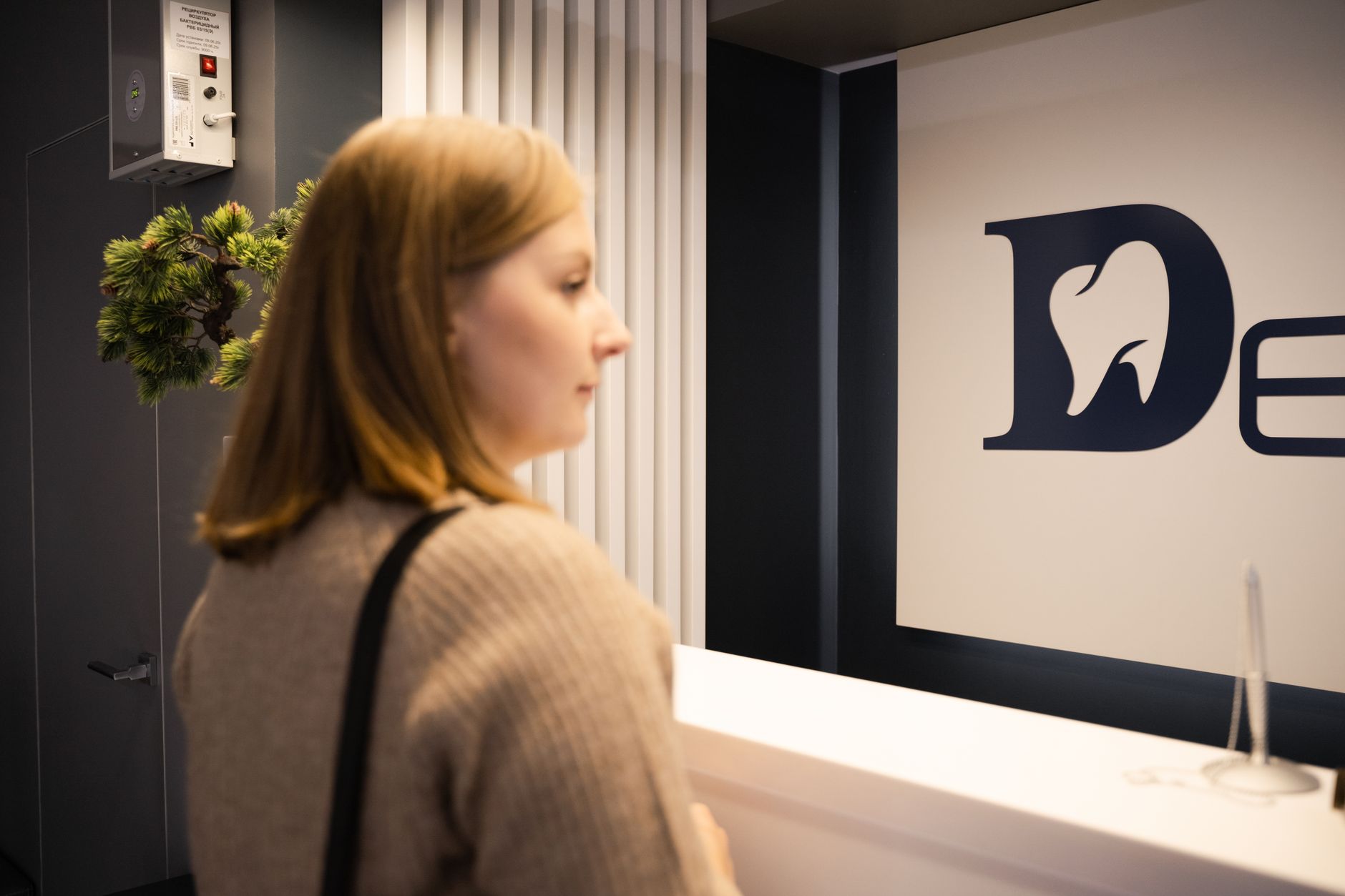 Patient standing at a dental office reception desk