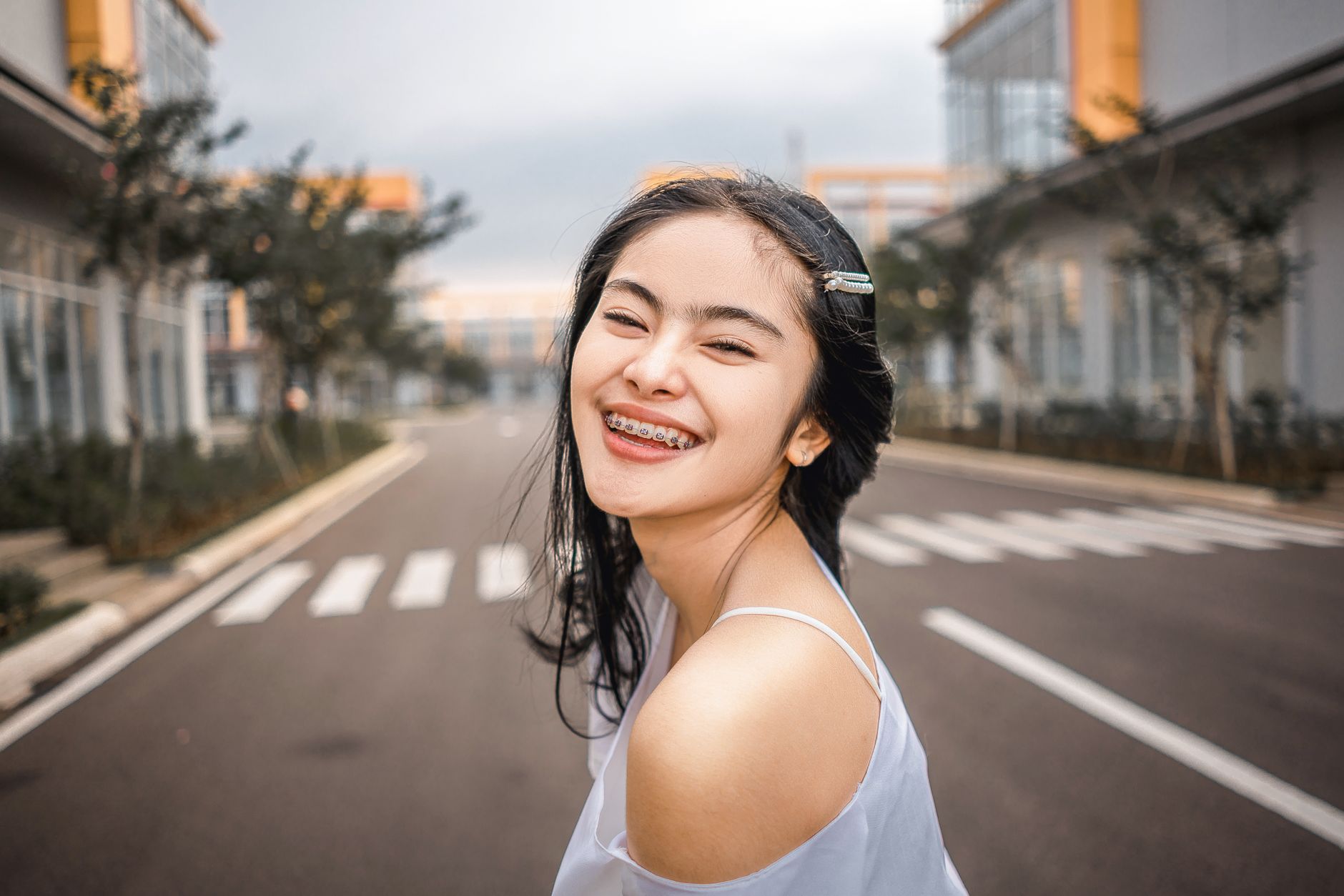 A young woman with orthodontic braces smiling outdoors